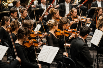 KI-generiertes Symbolbild: Symbolbild: Szene eines großen Orchesters mit Streich- und Blasinstrumenten