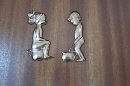 Toilettenzeichen für Mädchen und Jungen an einer Holztür
