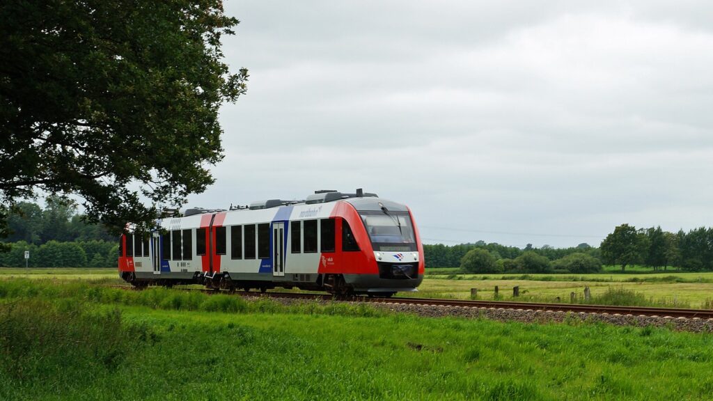 Ein Nordbahn-Triebwagen fährt durch eine grüne Landschaft bei Hohenwestedt