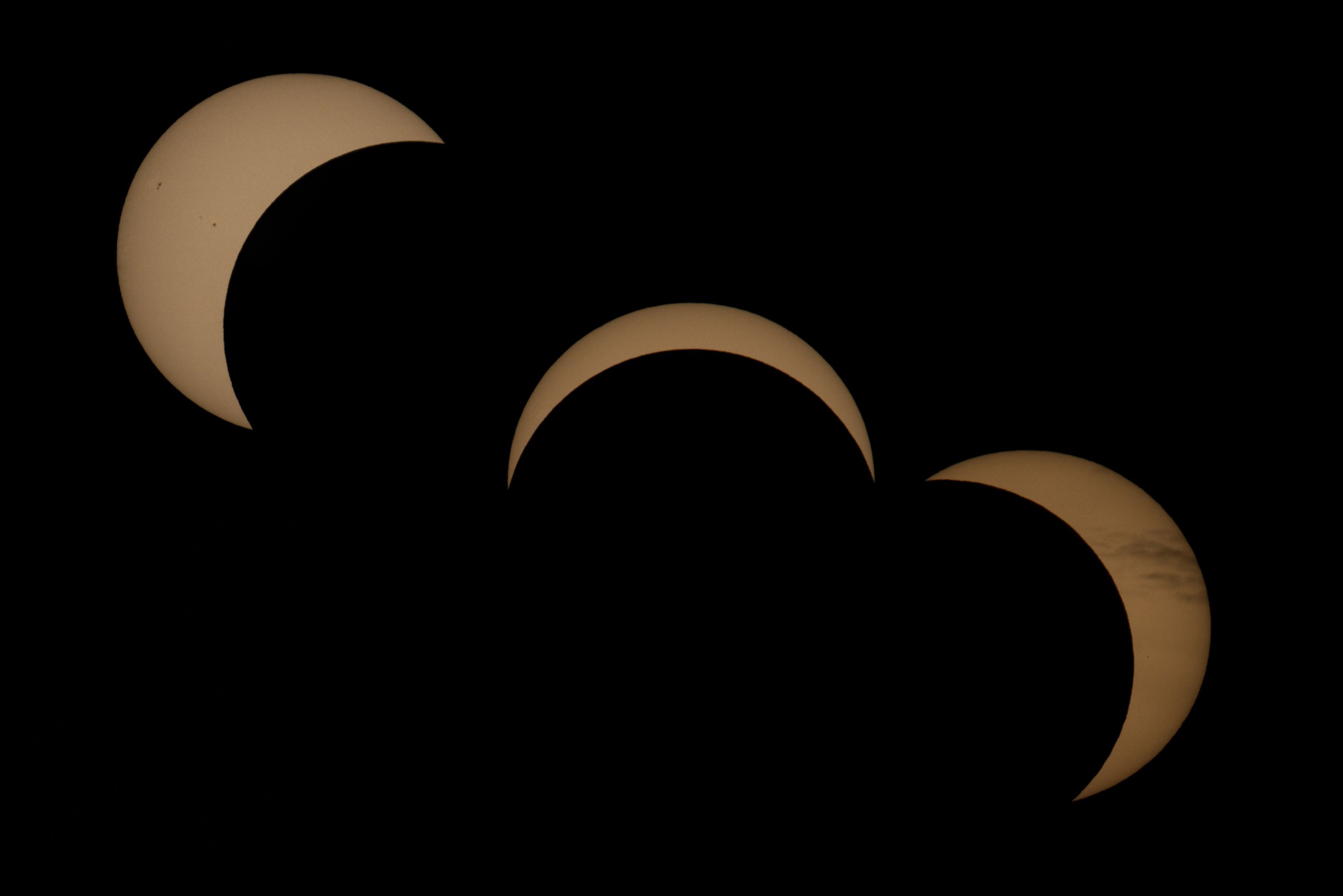 Drei Aufnahmen zeigen verschiedene Phasen der partiellen Sonnenfinsternis