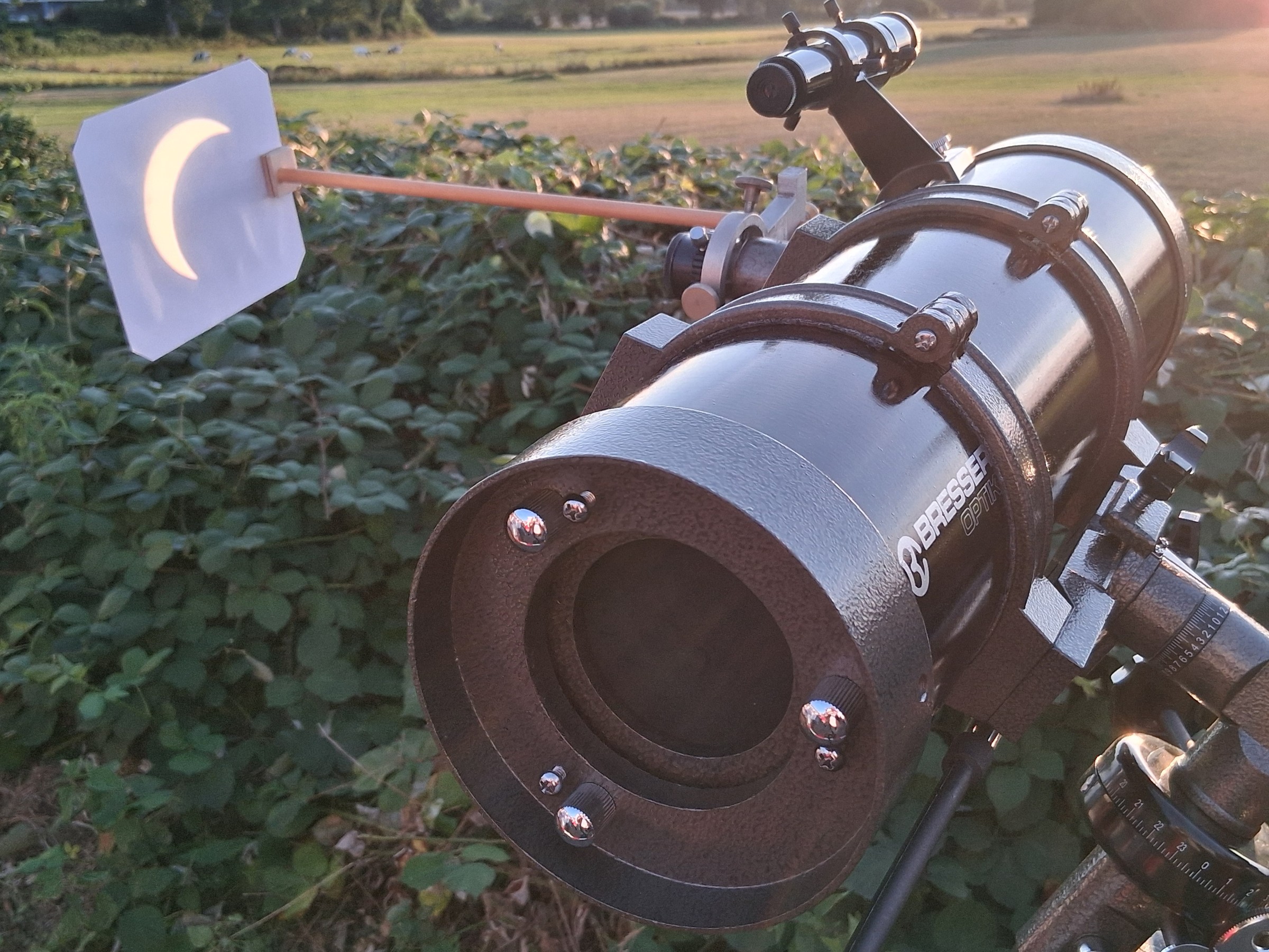 Ein Teleskop projiziert die schmale Sonnensichel auf eine weiße Fläche