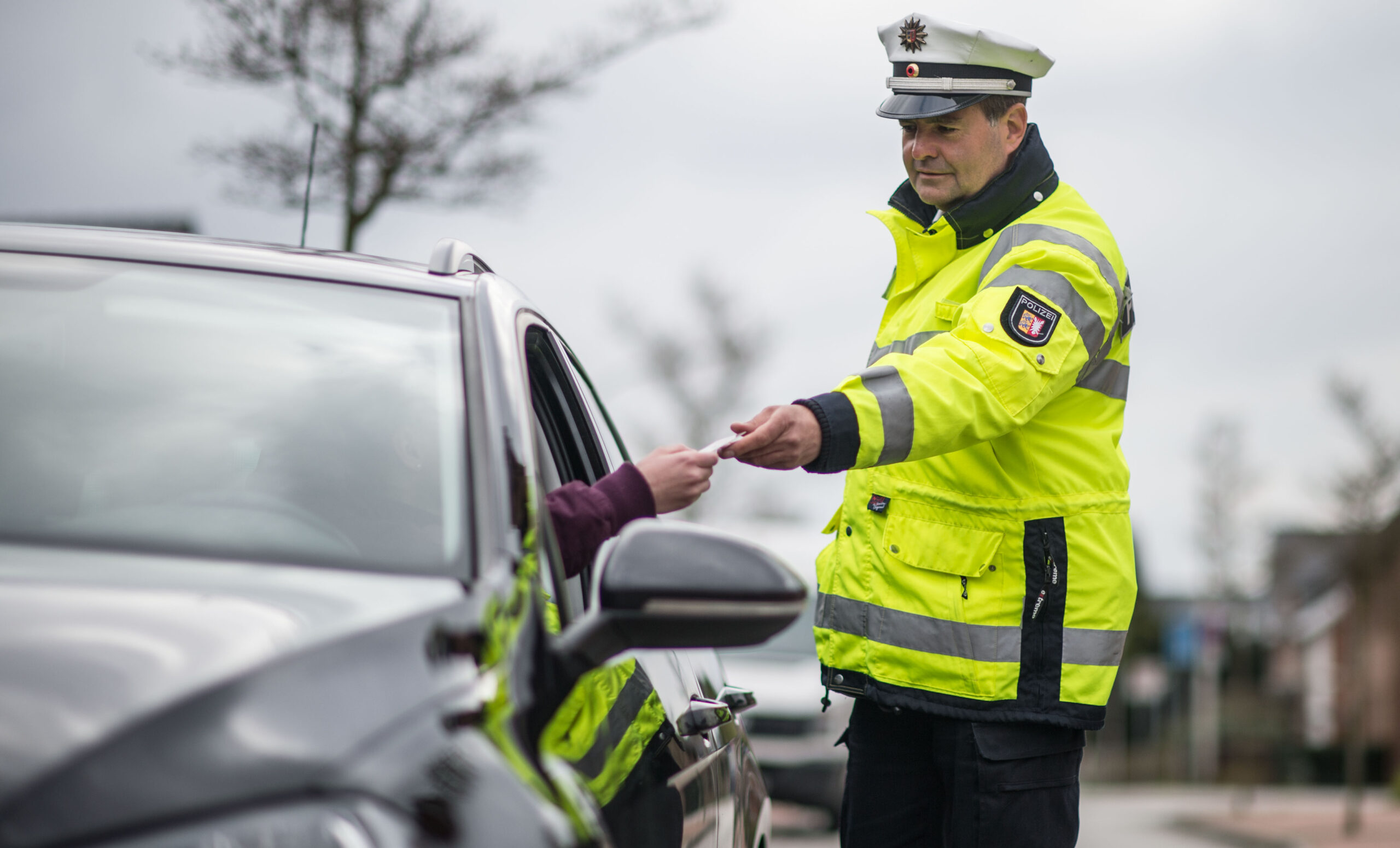 Polizeibeamte bei einer Verkehrskontrolle an einer Straße in Schleswig-Holstein